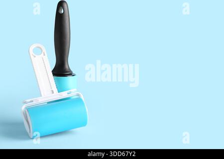 Lint rollers on blue background Stock Photo