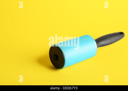 Lint roller on yellow background Stock Photo