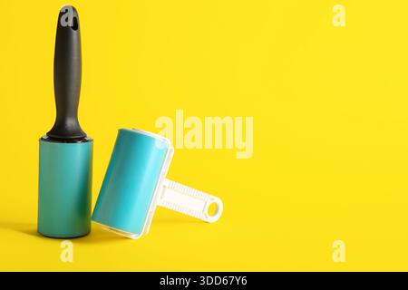 Different lint rollers on yellow background Stock Photo