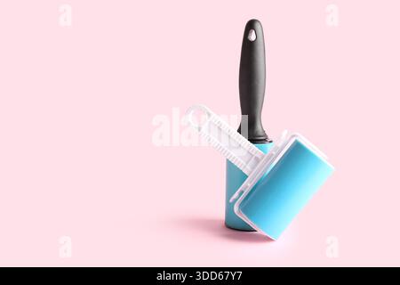 Different lint rollers on pink background Stock Photo