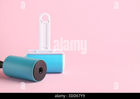 Different lint rollers on pink background Stock Photo