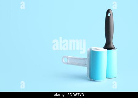 Lint rollers on blue background Stock Photo