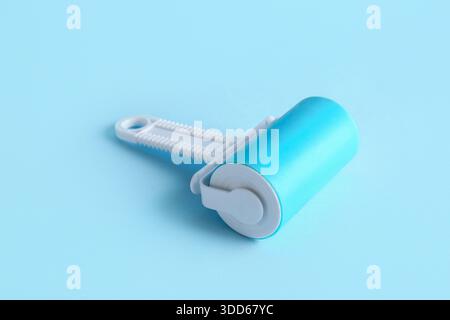 Lint roller on blue background Stock Photo