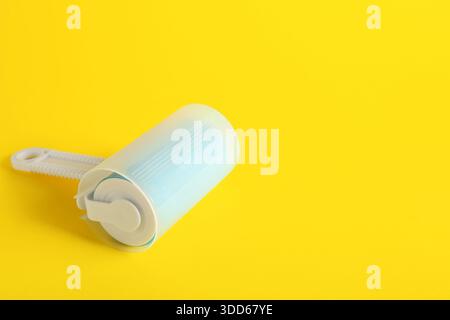 Lint roller on yellow background Stock Photo
