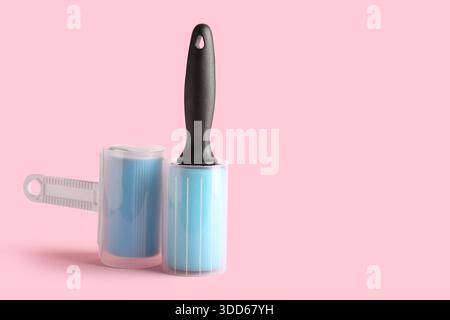 Different lint rollers on pink background Stock Photo