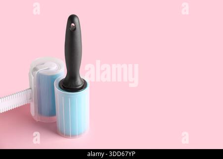 Different lint rollers on pink background Stock Photo