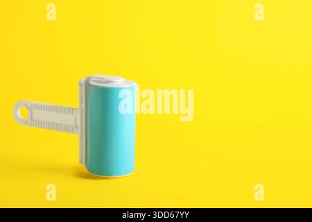 Lint roller on yellow background Stock Photo