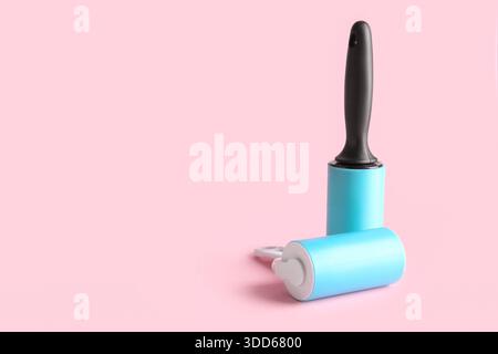 Different lint rollers on pink background Stock Photo