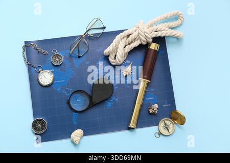 Composition with compasses, rope, spyglass and world map on blue background Stock Photo