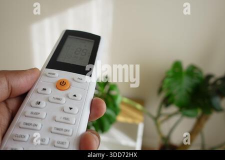 Hand holds a remote control for air conditioning unit Stock Photo