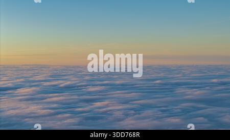 A large area of clouds can be seen while the sky glows in soft colors. The moment shows the transition from night to day. Grandsberg, Lower Bavaria Stock Photo