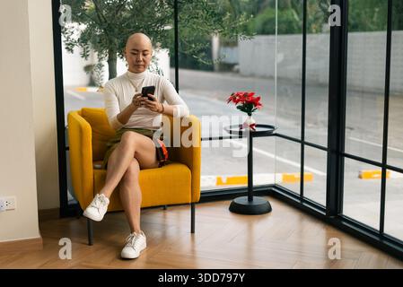 Bald asian woman communicating with smartphone, modern digital lifestyle Stock Photo