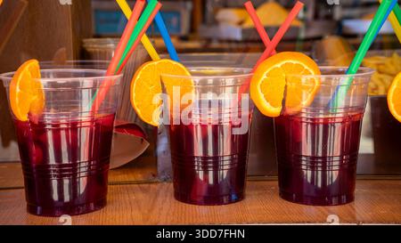 Three cups with colorful straws and orange slices., beverage Stock Photo