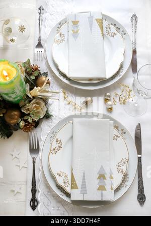 Elegant and festive setting, perfect for the Christmas table, with white, gold and silver-grey colors. Christmas decorations with baubles, candle. Stock Photo