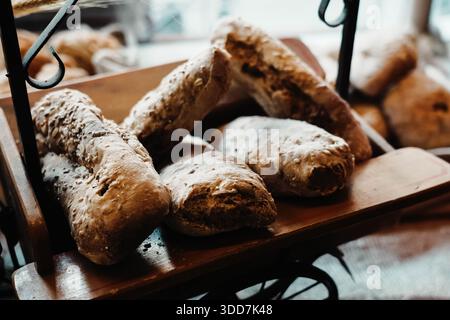 Loaves arranged in a showcase. Homemade products from a bakery. Healthy food, carbohydrates and wholemeal bread. Cereals and floury foods. Stock Photo
