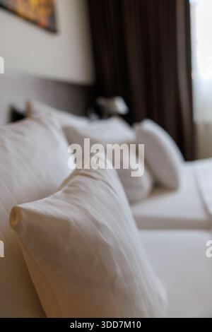 A close-up shot of a white sofa with several pillows in a modern living room. Stock Photo