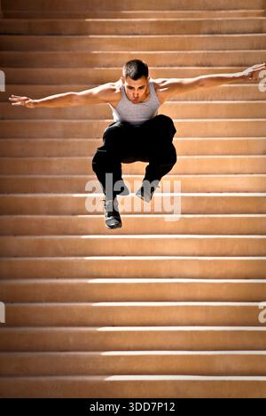 An athletic young man jumps while practicing parkour in Albuquerque, New Mexico. Stock Photo