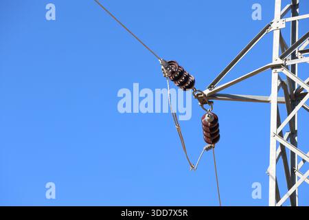 Close-up of High-Voltage Power Line Suspension Insulators and Connection Point on an Electrical Transmission Tower Pylon Stock Photo