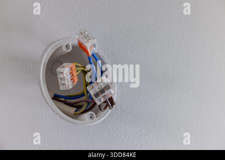 electric wires in the recessed wall junction box connected with splicing connectors. electrical installation Stock Photo