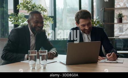 Two business men team in office multiethnic African American businessman sharing good idea Caucasian boss ecxited agree communicating diversity Stock Photo