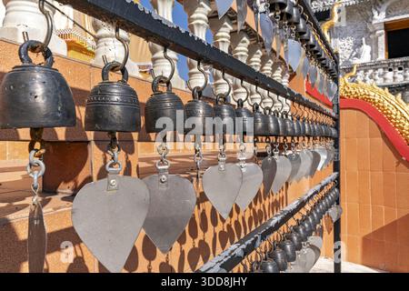 DOK KHAM TAI, PHAYAO, THAILAND - DECEMBER 29, 2025: Sri Chum Temple, A row of temple bells with heart-shaped metal wind catchers hanging on Stock Photo