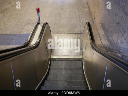 Empty escalator in modern subway station. Underground public transport infrastructure, urban mobility concept, city commute, clean interior, no people Stock Photo