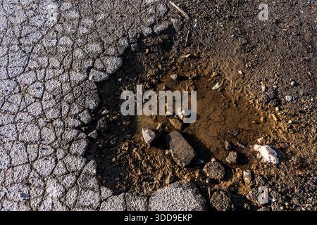 Pothole, asphalt surface, ground, with many small cracks, road, car park, Stock Photo