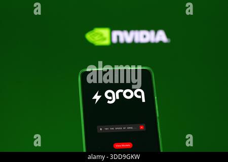 Groq AI on a smartphone foreground, the blurred Nvidia logo in the background. Stock Photo