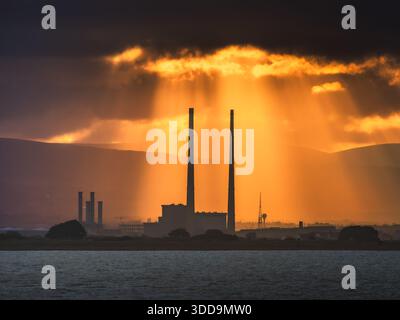 Sun rays beaming down on the Poolbeg Chimneys Stock Photo