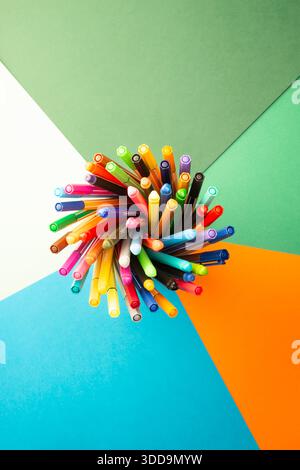 Creative workspace concept with multicolored pens arranged in a radial pattern, representing innovation, teamwork, and strategic thinking Stock Photo