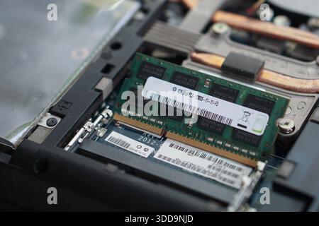 A memory module poised in the slot at an angle, ready to be pushed down and locked into place. Symbolizes system improvement and performance boosting. Stock Photo