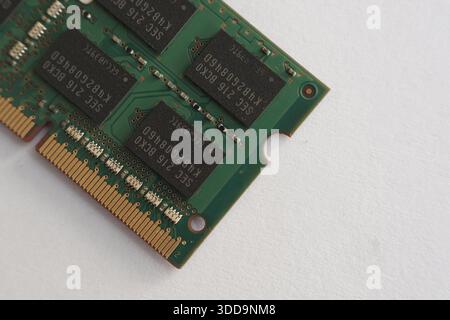 focused shot on the corner of a RAM stick, showing the mounting notch and the edge of the memory chips. precise manufacturing detail on white backgrou Stock Photo