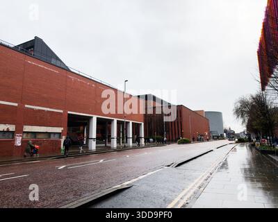 Manchester, UK - December 06, 2025: Urban scene in Manchester showing pedestrians, buses, and modern architecture on a wet, overcast day. Stock Photo
