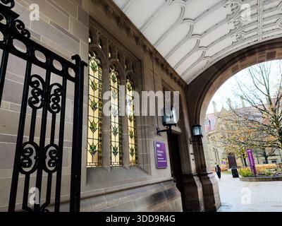 Manchester, UK - December 06, 2025: Arched entrance, lanterns, and decorative stained glass create a classic Manchester building scene. Stock Photo