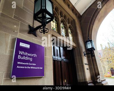 Manchester, UK - December 06, 2025: A grand university entrance at Whitworth Building with purple signage, lanterns, stained glass, and arches. Stock Photo