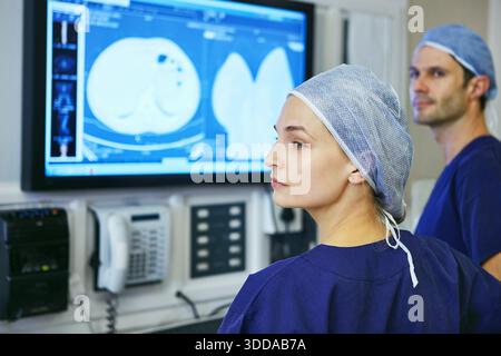 Surgery, team and mri scan with people in theater of hospital for operation, medical support and consulting. Ct chart, healthcare and surgeons or Stock Photo