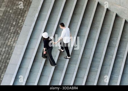 Business people walking down stairs in office building Stock Photo