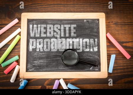 Website Production Concept Shown On Chalkboard With Magnifying Glass And Colorful Chalk Sticks Stock Photo