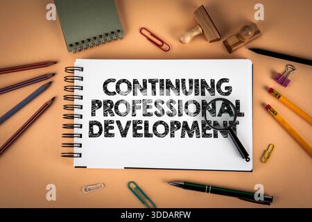 Continuing Professional Development Concept Shown On Notebook With Magnifying Glass And Stationery Stock Photo