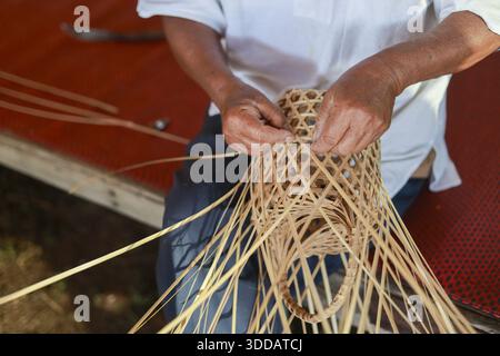 Close up of skilled craftsman hands weaving intricate bamboo basket with focused dedication traditional handmade craft making process showing cultural Stock Photo