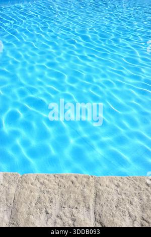The edge of an outdoor swimming pool. Stock Photo