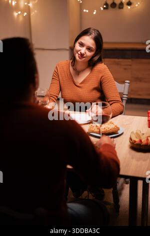 Happy young couple in love having dinner together celebrating Valentine's day at home, date at table. Stock Photo