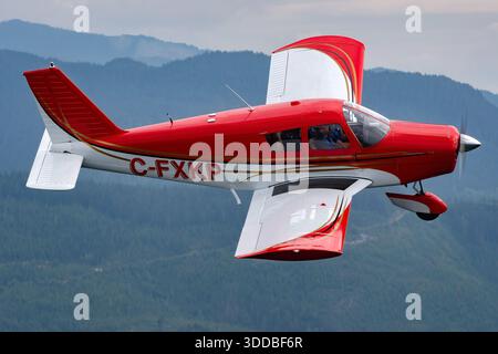 A Piper PA-28-140 Cherokee, registered C-FXKP with serial number 28-22195, is presented in a close-up pilot view at the Abbotsford International Airshow in Canada in 2035. The aircraft is a single-engine, low-wing design accommodating four seats and fixed tricycle landing gear. The image emphasizes cockpit layout, flight controls, and pilot interaction. The aircraft participates in a public general aviation display, showcasing the handling, operational features, and design of the Piper Cherokee series. Stock Photo