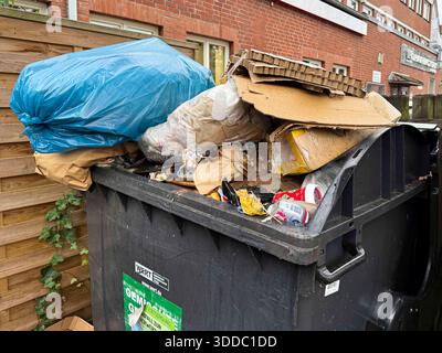 abb: Uebervoller Grosser Plastik Muell Container mit Muell nach den Feiertagen Hausmuell Papier Dreck am Boden Hamburg Deutschland *** ab Overfull large plastic garbage container with garbage after the holidays household garbage paper dirt on the ground Hamburg Germany Stock Photo