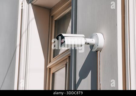 Surveillance camera providing protection and modern security on an outdoor wall, ensuring constant monitoring and safety Stock Photo