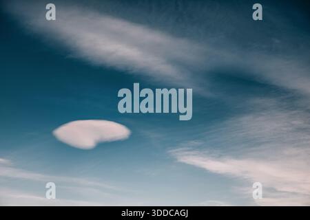 Lenticular cloud forming in a blue sky, conveying concepts of weather, and calm atmosphere Stock Photo