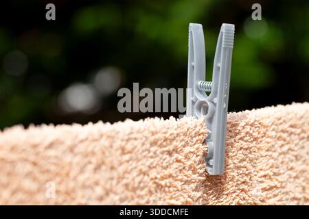 Macro image of a clothes peg and washing on a domestic line Stock Photo