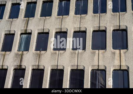 abstract close-up of the windows of a mid-century modern concrete hotel building, multi-storey office block windows in an abstract composition. Stock Photo