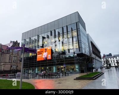 Manchester, UK - December 06, 2025: Contemporary glass facade in Manchester with a bright graduate careers banner and street signs. Stock Photo