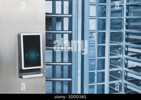 Contactless card reader with wireless signal symbol next to a security turnstile, managing entry and exit access Stock Photo